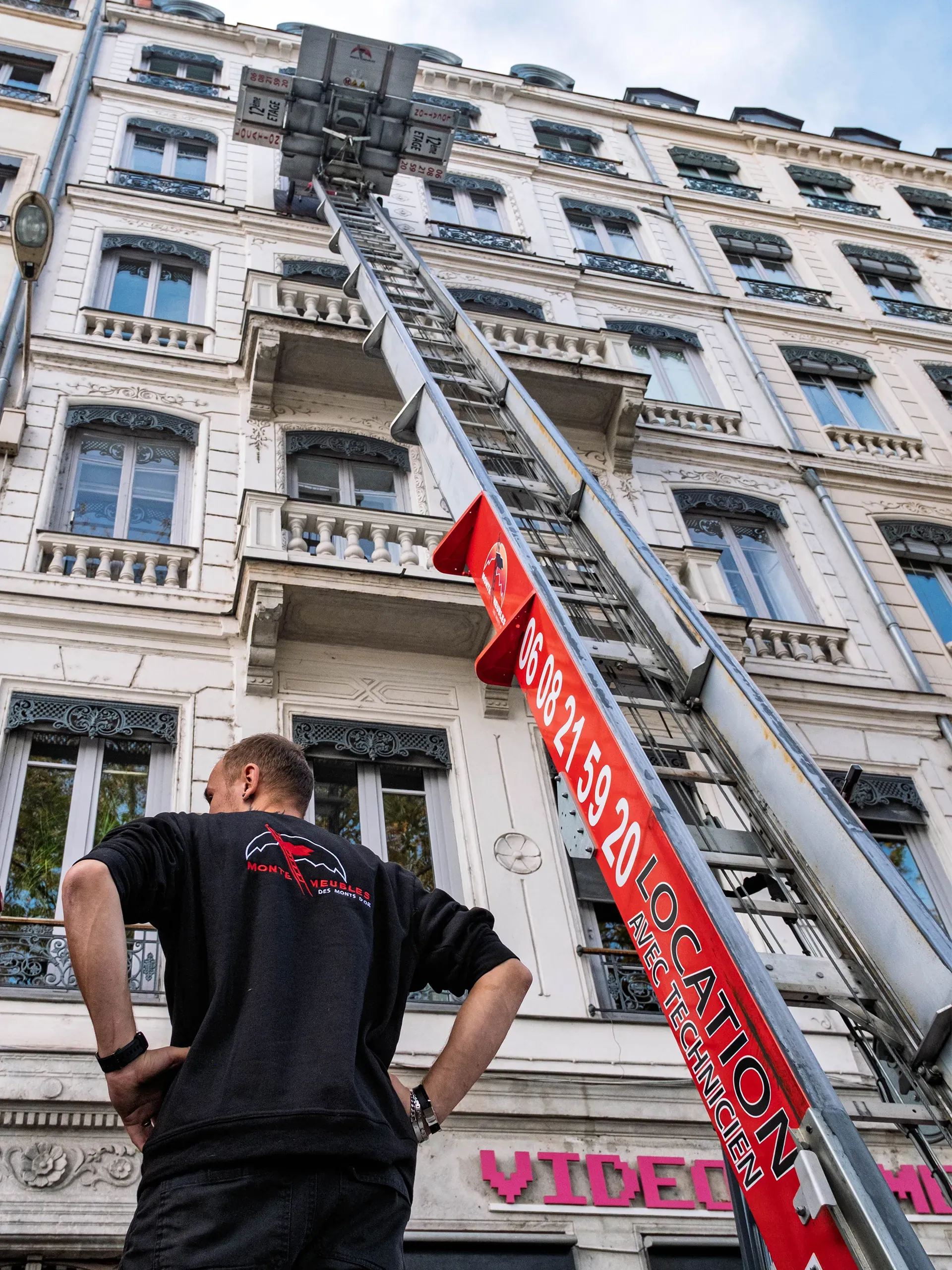 Technicien devant un monte-meubles sur un immeuble haussmannien à Lyon